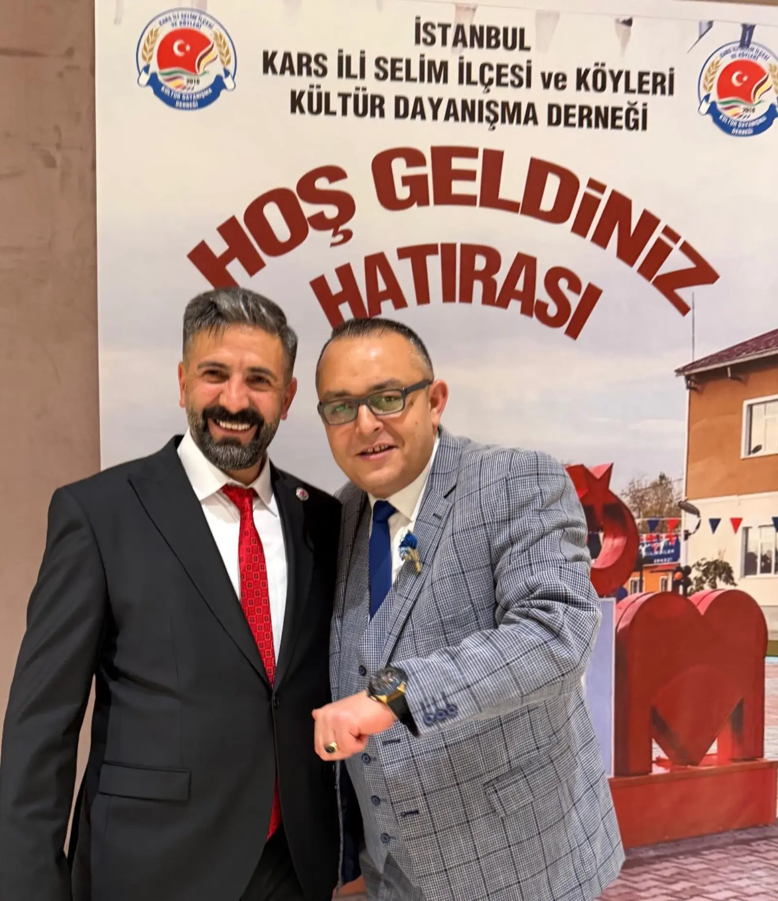 Bir dernek gecesinde Hoş Geldiniz panosu önünde dernek başkanıyla